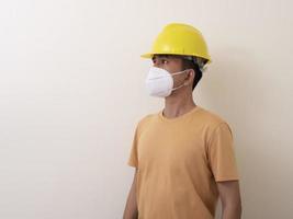 los trabajadores industriales asiáticos usan cascos amarillos, usan máscaras protectoras para su salud foto