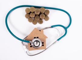 Check up house and investment concept. Stethoscope with miniature house and money photo