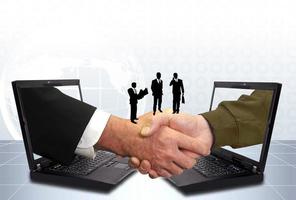 Hand shake between a businessman and a laptop photo