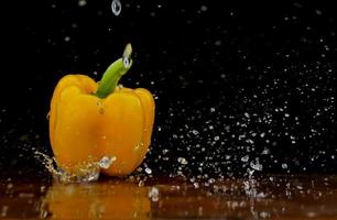 Yellow pepper in water stream photo