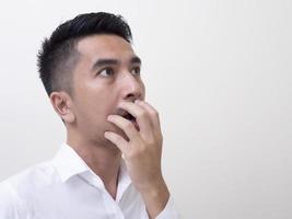 Shocked face of Asian man in white shirt on white background. photo