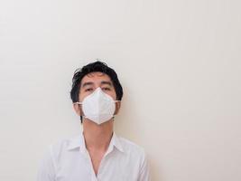 Asian young man in white shirt and medical mask to protect COVID-19 photo