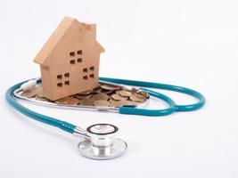 Check up house and investment concept. Stethoscope with miniature house and money photo