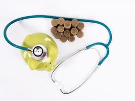 piggy bank with coins and stethoscope photo