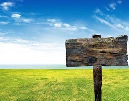 wood sign on beach and sea photo