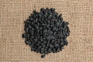 Black turtle beans on on sack background. photo