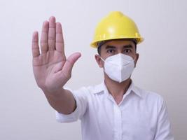 Asian industrial workers wear yellow hard hats, wear protective masks for their health photo