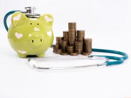 piggy bank with coins and stethoscope photo