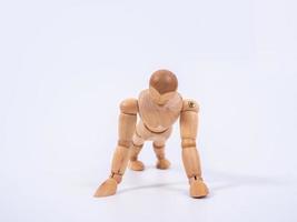 Small wooden dummy during push ups on white background photo