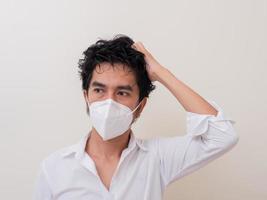 Asian young man in white shirt and medical mask to protect COVID-19 photo