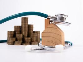 Check up house and investment concept. Stethoscope with miniature house and money photo