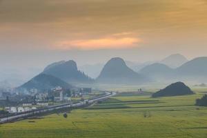 Yellow rapeseed flower field with the mist in Luoping, China photo