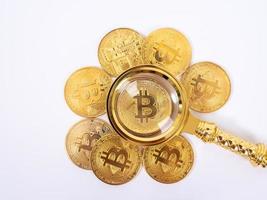 Golden bitcoin magnifying glass on a blurred background of coins photo