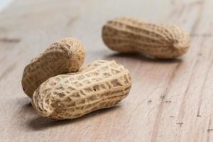 peanuts in shells over wood background photo