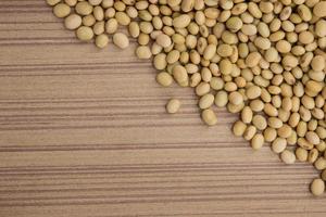 Dry soybeans on wooden board photo