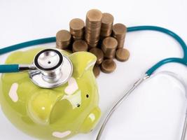 piggy bank with coins and stethoscope photo