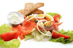 fresh salmon salad, lettuce and quail eggs photo