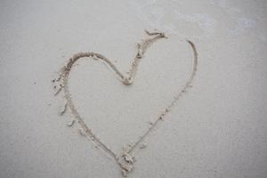 corazones dibujados en la arena de una playa foto