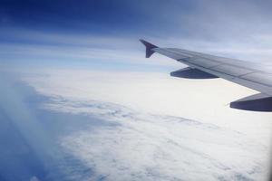 Wing of an airplane flying above the clouds. photo