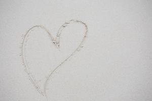 hearts drawn on the sand of a beach photo