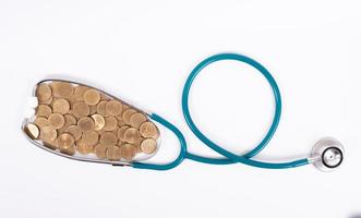 Medical stethoscope and coins stack isolated on white background. Medical insurance concept. photo