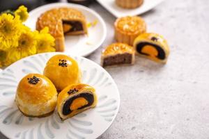 Tasty baked egg yolk pastry moon cake for Mid-Autumn Festival on bright cement table background. Chinese traditional food concept, close up, copy space. photo