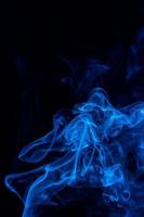 imagen conceptual de humo de color azul aislado sobre fondo negro oscuro, concepto de elemento de diseño de Halloween. foto