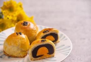 Tasty baked egg yolk pastry moon cake for Mid-Autumn Festival on bright cement table background. Chinese traditional food concept, close up, copy space. photo