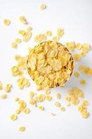 Corn flakes bowl sweeties with milk and orange on white background, top view, flat lay overhead layout, fresh and healthy breakfast design concept. photo