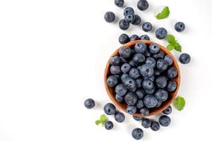 Blueberry fruit top view isolated on a white background, flat lay overhead layout with mint leaf, healthy design concept. photo