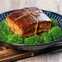 Dong Po Rou Dongpo pork meat in a beautiful blue plate with green broccoli vegetable, traditional festive food for Chinese new year cuisine meal, close up. photo