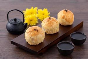 Moon cake yolk pastry, mooncake for Mid-Autumn Festival holiday, close up design concept on dark wooden table background photo