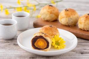 Moon cake yolk pastry, mooncake for Mid-Autumn Festival holiday, top view design concept on bright wooden table with copy space photo