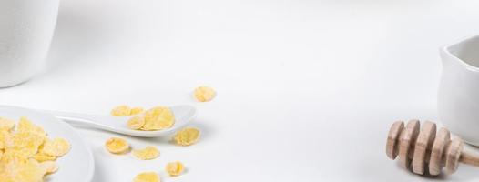dulces de copos de maíz con leche y naranja sobre fondo blanco, primer plano, concepto de diseño de desayuno fresco y saludable. foto