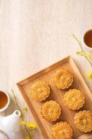 Mid-Autumn Festival holiday concept design of moon cake, mooncakes, tea set on bright wooden table with copy space, top view, flat lay, overhead shot photo