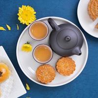 Moon cake for Mid-Autumn Festival, delicious beautiful fresh mooncake on a plate over blue background table, top view, flat lay layout design concept. photo