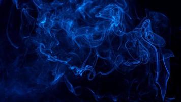 imagen conceptual de humo de color azul aislado sobre fondo negro oscuro, concepto de elemento de diseño de Halloween. foto