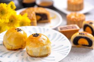 Tasty baked egg yolk pastry moon cake for Mid-Autumn Festival on bright cement table background. Chinese traditional food concept, close up, copy space. photo