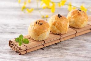 Moon cake yolk pastry, mooncake for Mid-Autumn Festival holiday, top view design concept on bright wooden table with copy space photo