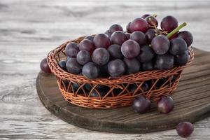 primer plano de racimo de uvas sobre fondo de mesa de madera.