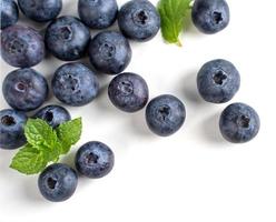 Blueberry fruit top view isolated on a white background, flat lay overhead layout with mint leaf, healthy design concept. photo