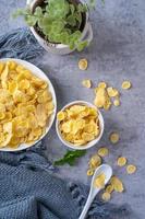 Corn flakes bowl sweets on gray cement background, top view flat lay layout design, fresh and healthy breakfast concept. photo