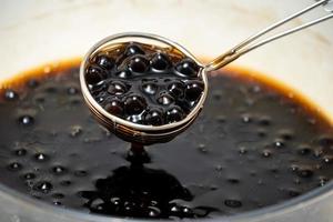 Cooking, boiling brown sugar flavor tapioca pearl balls, ingredient of bubble tea, preparing food and drink, close up, recipe cookbook steps design concept. photo
