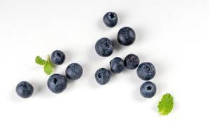 Blueberry fruit top view isolated on a white background, flat lay overhead layout with mint leaf, healthy design concept. photo