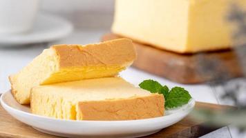 Plain classic Taiwanese traditional sponge cake Taiwanese castella kasutera on a wooden tray background table with ingredients, close up. photo