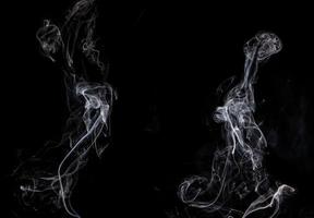 Conceptual image of white color smoke isolated on dark black background, Halloween design element concept. photo