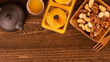 Moon cake for Mid-Autumn Festival, delicious beautiful fresh mooncake on a plate over dark wooden background table, top view, flat lay layout design concept. photo
