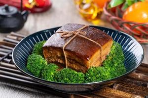 Dong Po Rou Dongpo pork meat in a beautiful blue plate with green broccoli vegetable, traditional festive food for Chinese new year cuisine meal, close up. photo