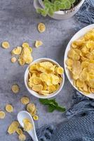 Corn flakes bowl sweets on gray cement background, top view flat lay layout design, fresh and healthy breakfast concept. photo