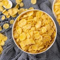 Corn flakes bowl sweets on gray cement background, top view flat lay layout design, fresh and healthy breakfast concept. photo